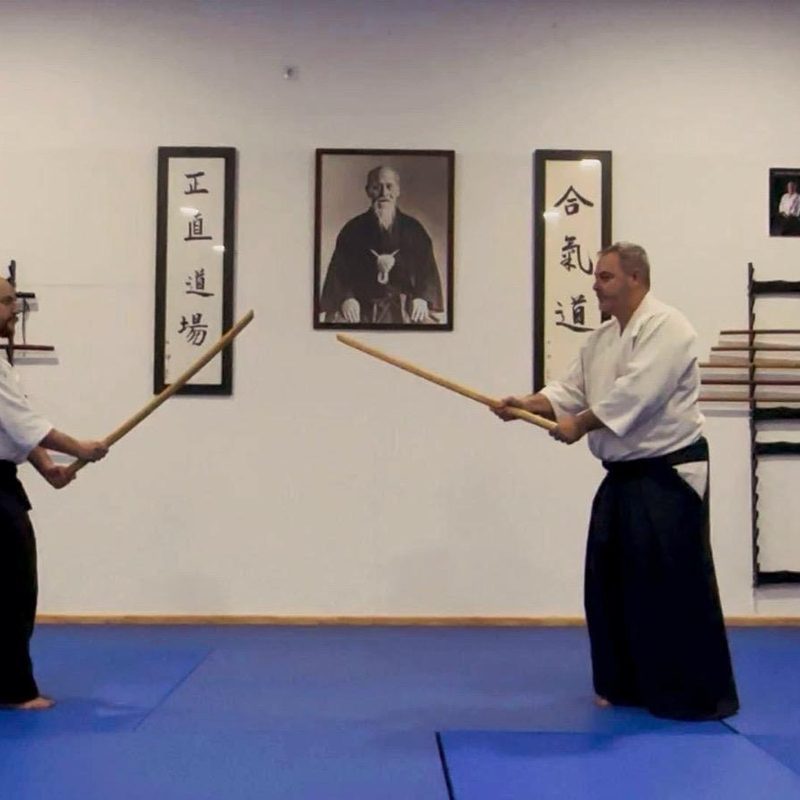 Kata con bokken frente al cartel Shojiki Dojo